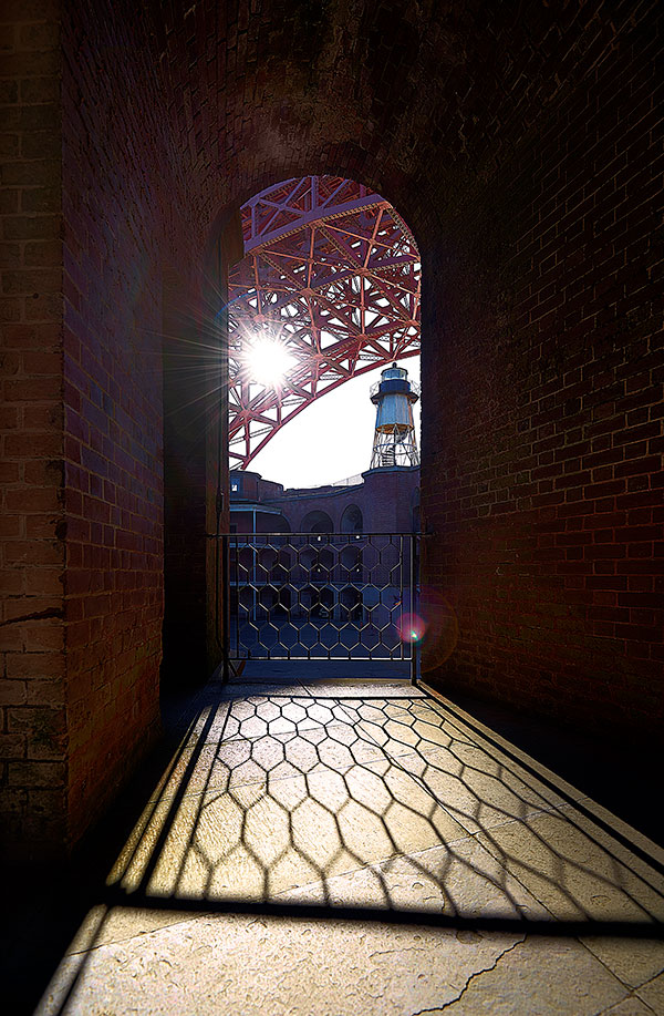 Photo of the sun setting behind the Golden Gate Bridge from Fort Point, San Francisco, California by visionbypixels.com