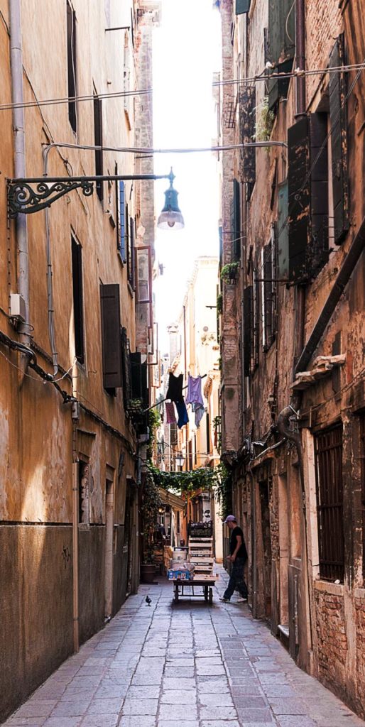 Photo of a delivery worker in an alley in Venice, Italy, by visionbypixels.com